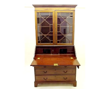 A Georgian mahogany bureau bookcase with a pair of astragal glazed doors over slope front enclosing fitted interior and four 