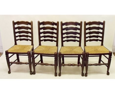 A set of four rush seated ladder back dining chairs