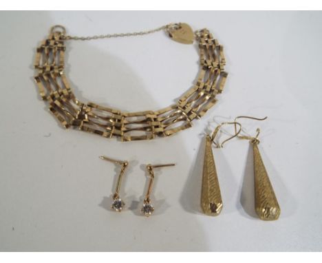 A lady's 9 carat gold gate bracelet with safety chain padlock and two pairs of presumed 9 carat gold earrings (unmarked), app
