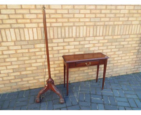 A mahogany hall table with single drawer on tapered supports, and an early 20th C standard lamp raised on ball and claw feet 