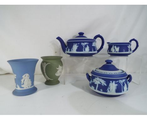 Wedgwood - Five pieces of Wedgwood Jasperware comprising three dark blue items to include teapot, cream jug and sugar bowl, a