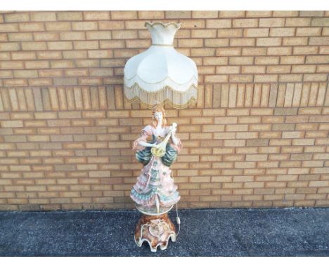 A standard lamp in the form of a flamenco dancer with stringed instrument, possibly Capodimonte, with shade, 