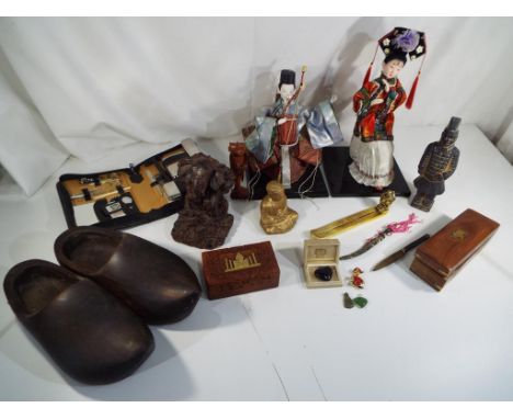 A good mixed lot to include a pair of wooden clogs, carved wooden trinket boxes, two Asian figurines, a carved wooden Buddha 