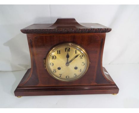 An unusual early 20th century polished mahogany cased mantel clock, applied contrasting veneers and inlaid stringing, silvere