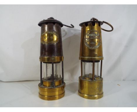 Two miners type safety lamps in brass and metal , one marked The Protector Lamp and Lighting Co Ltd Eccles Manchester and the