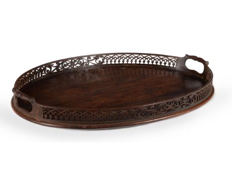 A GEORGE III MAHOGANY OVAL TRAY IN THE MANNER OF THOMAS CHIPPENDALE, CIRCA 1770 With pierced fretwork gallery6cm high, 59cm w