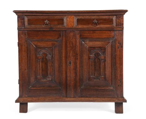 A CHARLES II OAK, FRUITWOOD AND SNAKEWOOD ENCLOSED CHEST OF DRAWERS CIRCA 1670 The moulded panel doors opening to three long 