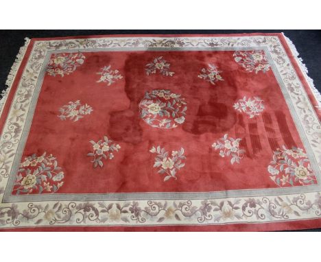 A 20th century Chinese wool carpet, woven with pastel floral sprigs on a peach and cream ground within a broad single guard, 