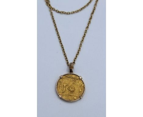 A yellow metal moghul type coin, in a mount, on a 9ct marked chain&nbsp;