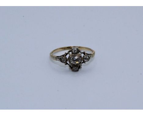 An 18th century diamond set ring featuring a central off oval shaped old mine cut diamond, close back bezel set, surrounded b