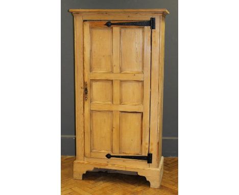 A pine cupboard of large size and tall proportion, enclosed by a full length panel door, h148cm