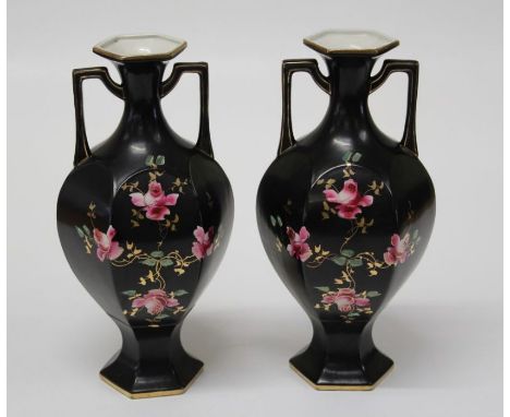 A pair of Edwardian twin handled vases of hexagonal form, each enamel and gilt decorated with pink roses, on a black ground, 