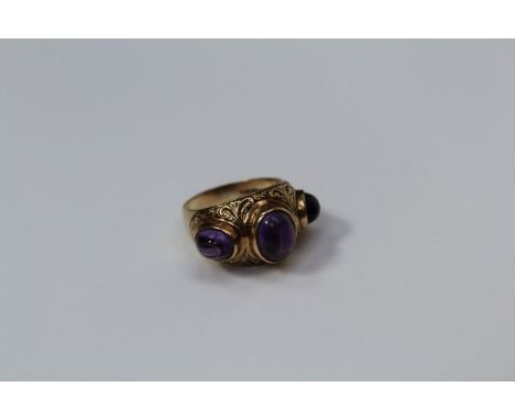 A 9ct gold ring, set three cabochon amethyst, to a part textured shank, 8gms gross weight, size R