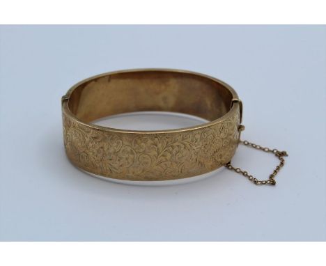 A 9ct carat gold hinged bangle with safety chain, 24 grams&nbsp;approximately, diameter 7cm