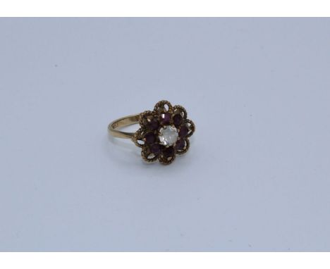 A ruby and white zircon set flower ring in 9ct gold, size M. Gross weight approximately 3.2 grams