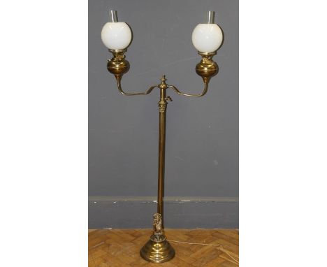 A 19th century style floor standing two light brass oil lamp standard having a base with lion Sergeant decoration, h160cm une
