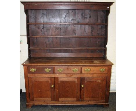 An early 19th century oak tall dresser, the later rack over drawers and cupboards, on bracket feet, 200 x 165 x 54cm