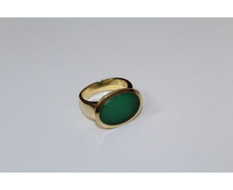 An 18ct gold ring, set oval jade panel, to a plain shank. Import marks rubbed, 14 gm gross weight, size S