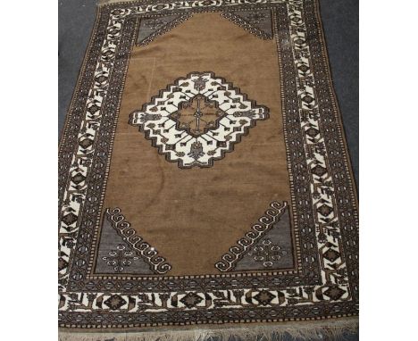 A Persian Nomadic style hand knotted carpet having a brown ground with ivory medallion, 330 x 219cm&nbsp;