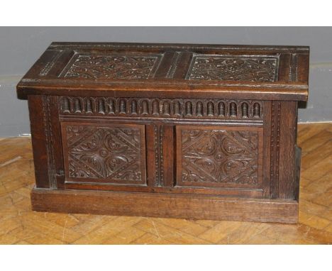 A 17th century style carved oak two panel coffer having a rising top, raised on a plinth base, w90.5cm