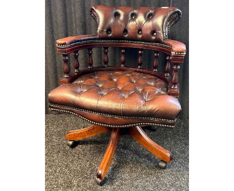 Chesterfield captains chair covered in a brown button back upholstery, with brass nail head trim