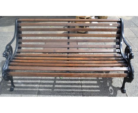 A cast iron garden bench with scroll arms on paw supports, cast with design registration lozenge 