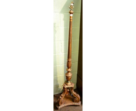 ~ A giltwood standard lamp on triform base 