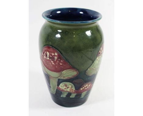 A William Moorcroft vase Of cylindrical form with flared neck, decorated in the Claremont pattern on a green ground, impresse