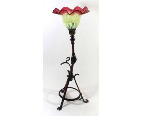 An Arts & Crafts brass table lampWith rotating arm which holds a vaseline and cranberry glass shade, raised tripod base, heig