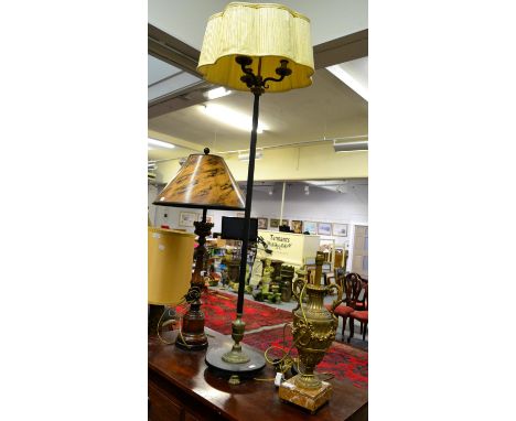 A gilt and patinated metal three light standard lamp, a gilt urn form table lamp and a carved wooden table lamp