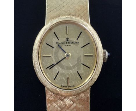 A lady's 18ct gold Baume and Mercier manual wind wrist watch, with textured oval dial and baton numerals, on integral 18ct go