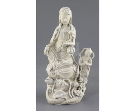 A Chinese Dehua blanc de chine group of Guanyin and an attendant, the figure holding a lotus sprig and seated on lotus, impre