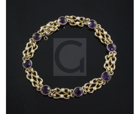 An Edwardian 15ct gold, amethyst and seed pearl bracelet, with shaped links and set with eight round cut amethysts, 17cm.