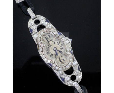 A stylish 1930's Art Deco French platinum, diamond and synthetic? sapphire set oval cocktail watch, with shaped Arabic quatre