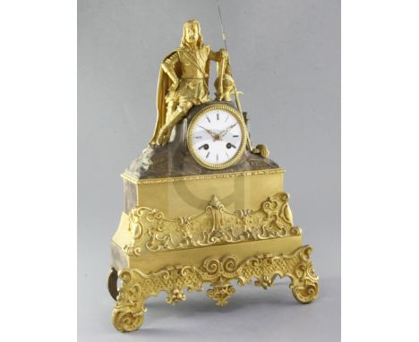 A French Régence gilt and patinated ormolu mantel clock, surmounted by the figure of a seated knight, the 3.5 inch Roman enam