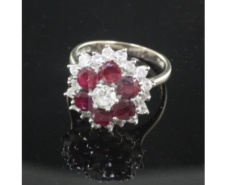 A 1970's 18ct white gold, ruby and diamond cluster ring, of flowerhead design and set with six round cut rubies, size N.From 