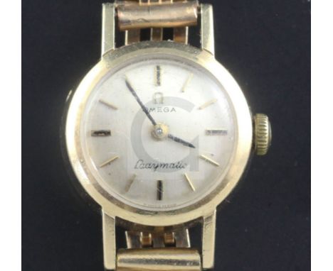 A lady's 9ct gold Omega manual wind wrist watch, on a gold plated bracelet.