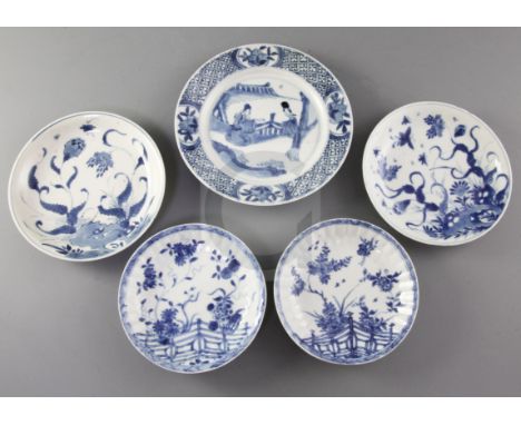 Four Chinese blue and white saucer dishes, and a similar plate, Kangxi period, the saucers painted with flowers and rockwork 