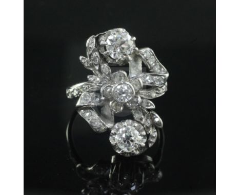 An 18ct white gold and diamond cluster upfinger ring, set with rose cut and three larger round cut diamonds, size M.