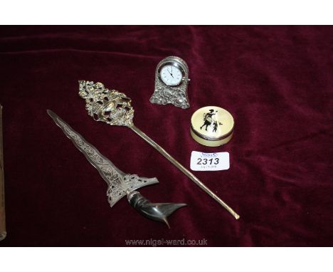 Two white metal letter openers, a miniature plated clock and an enamelled compact