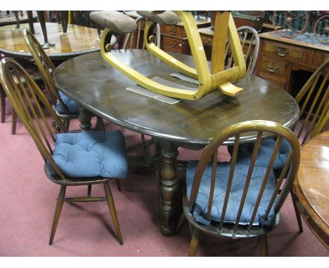 An Ercol Dining Suite, comprising six tall hoop back chairs and an extending 'D' ended table on turned and block supports uni