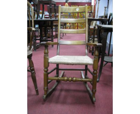 Beech Ladder Back Rocking Chair, with raffia seat, on turned and block supports united by turned stretcher.