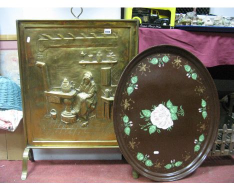 A Large Brass Firescreen, with impressed scene of an old lady sat at the side of a kitchen range, an oval tin decorated tray.
