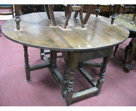 An XVIII Century Style Oak Drop Leaf Table, with carved frieze on turned and bobbin supports, united by stretchers.