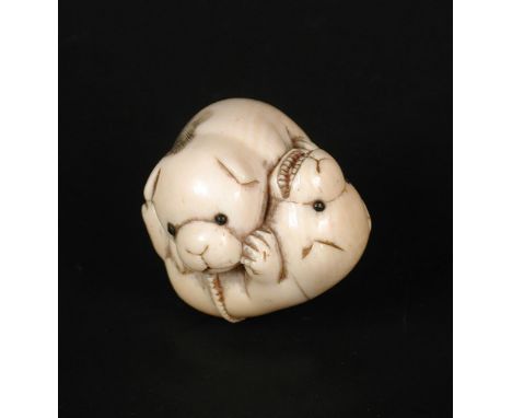 Masatami', a 19th century ivory netsuke carved as puppies playing, the one lying on its back by a shoe with its open mouth ti