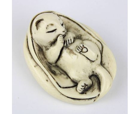 Elfenbein-Netsuke in Katzenform, Japan Anfang 20. Jh., sich in eine Decke kuschelndes Kätzchen, aus einem Stück geschnitzt, i