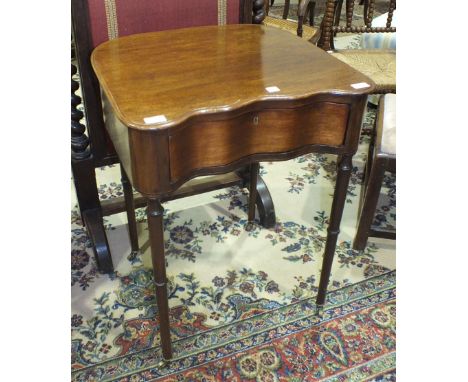 A mahogany shaped side table fitted with a serpentine drawer, on turned legs with castors, 57cm wide, 75cm high.