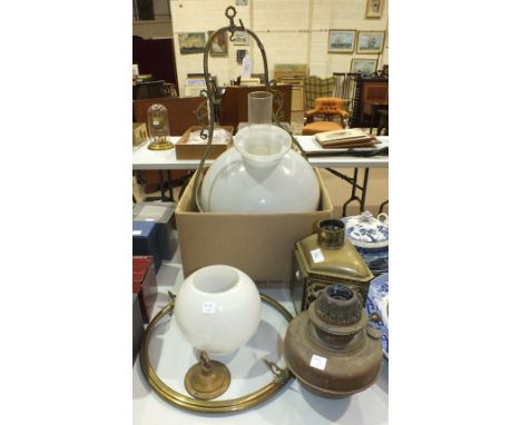 A brass hanging oil lamp with white glass shade, two other oil lamps, various boxed games and other items.