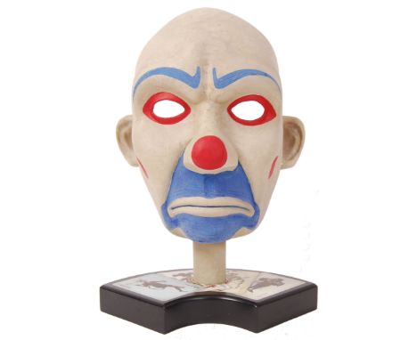 A rare and impressive Noble Collection made 1:1 scale ceramic prop replica of Heath Ledger's Joker's Mask. Standing on a deco