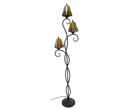 A 20thC cast metal standard lamp, with three leaded Tiffany style glass shades, on a circular base, 153cm high. 